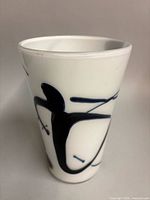 Front view showing white glass body with abstract blue black motif