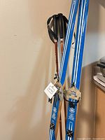 Karhu skis with Stride bindings and wooden poles leaning against wall