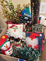 Boxed lot showing pillows, plush snowman, berry picks, lights, gift wrap