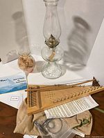Overview of psaltery, bow, tuning key in bag, booklet, oil lamp, glass vase