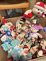 Box overview of assorted plush snowmen, wooden ornaments and plate