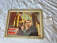 Framed lobby card showing film scene with gold wood frame and Lot 75 tag visible