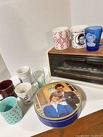 Group shot showing toaster oven, mugs, blue glass tumbler, Royal tin
