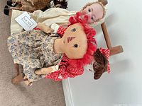 All three dolls on wooden chair