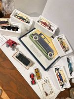 Overall view showing six boxed Ford die-cast cars, loose cars and print