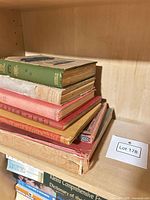 Stack of seven vintage hardcovers on shelf