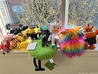 Full group of nine plush toys on windowsill