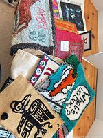 Overview of assorted latch-hook rugs, diamond canvas corner, patchwork runners