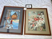 Both framed prints side by side on bed surface
