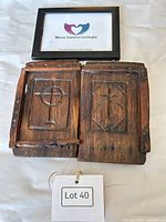 Front view of both carved wooden panels showing relief designs and wear