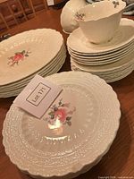 Stacks of plates and cups showing embossed rim and floral decal