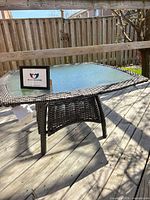 Overall angled view of wicker patio table on deck