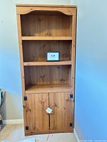 Full frontal view showing overall design with open shelves and lower cabinet