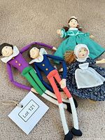 Four fabric rag dolls laid out on carpet