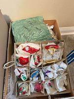 Open storage box showing 12 glass ornaments in individual compartments with tissue