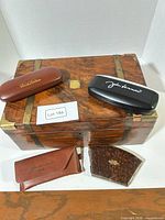 Group shot of box, two hard cases, pouch, compact