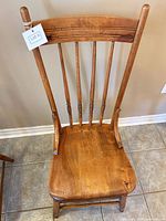Front view of vintage spindle-back chair showing seat, spindles, and turned legs