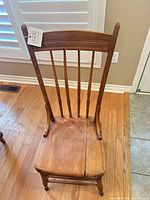 Front view of spindle-back wooden chair showing overall design and seat split