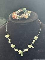 Necklace displayed on bust with bracelet on top