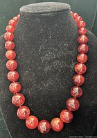 Front view of full necklace on bust form showing bead uniformity