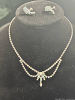 Necklace on bust with earrings above