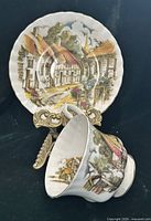 Teacup on saucer front view showing pattern and gold trim