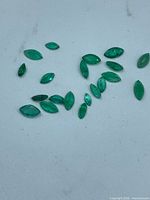 Group of small marquise emeralds on white background