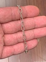 Bracelet held in hand showing rope-twist oval links
