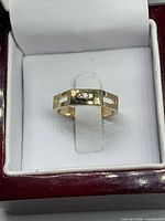 Ring front in box showing three channel-set crystals