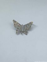 Front view of silver-tone butterfly charm fully covered with rhinestones