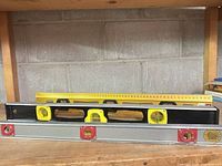 Three spirit levels stacked on shelf