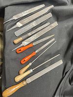 Nine assorted files and rasps laid out on black cloth
