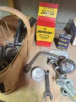 Overall view with boxed Dunlop tube, repair kit tin, bell parts, pedal, wrenches and basket of tools