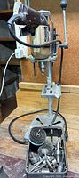 Full view of drill mounted in press with accessory tray