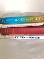 Stack of four titled books showing spines and thickness