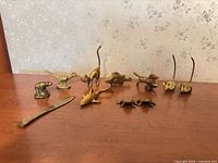 Group shot of all brass figurines and letter opener on surface