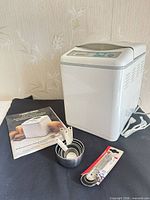 Breadmaker with manual, measuring cups and spoons