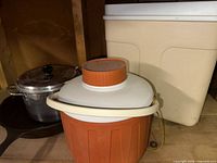 Group view showing aluminum pot, cast iron skillet, orange water jug, beige cooler