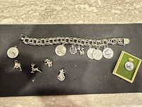Full view of bracelet with attached and loose charms