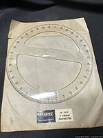 Full view of Bruning 1910P 8" circular protractor on original sleeve