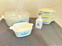 Group view of casseroles, lids and vinegar dispenser