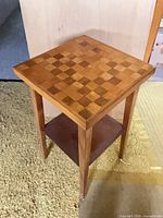 Full view of wooden games table showing checkerboard top and lower shelf