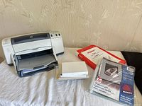 Printer with paper supplies on table
