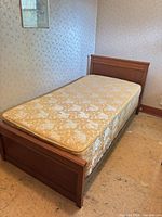 Full view of assembled single bed frame with mattress showing wooden headboard and footboard