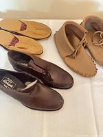Overall view of three pairs of men’s footwear on table