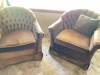 Front view of both brown tufted tub chairs showing overall design and condition