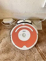 top view of Roomba with docking station and power adapter
