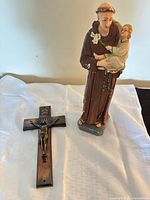 Statue and crucifix side by side