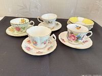 Group shot of four teacup-and-saucer sets with stack of extra saucers
