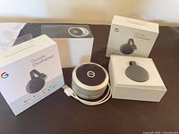 Two Chromecast boxes, one Chromecast device, XSound speaker and box displayed